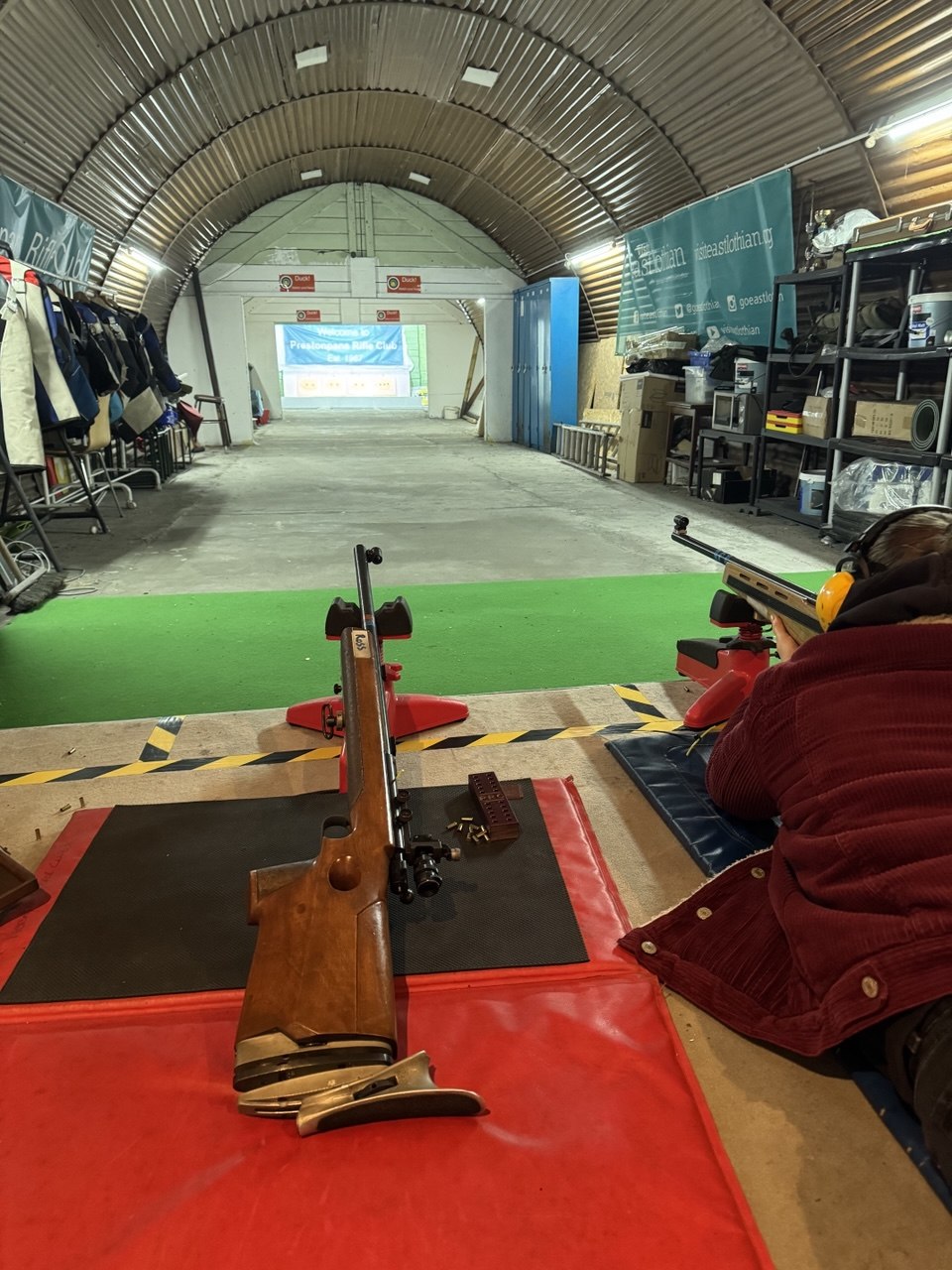 The shooting range in Prestonpans: a long indoor lane with shooting mats lined up in front of paper-target stands.